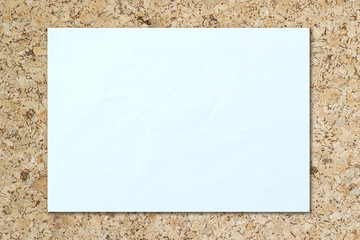 White paper with folds on a wooden floor.