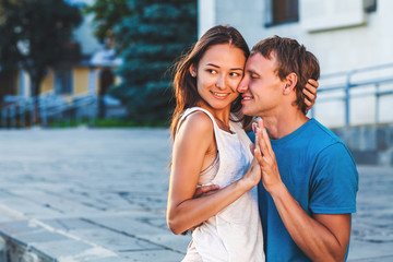 Obraz premium The guy embraces his girlfriend during a walk in the fresh air