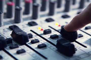 man sets up the mixer to adjust the sound and recording