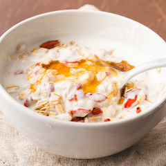 Smoothie bowl with natural yogurt, goji berries, oatmeal flakes and honey