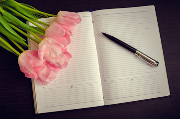 Beautiful pink tulips with a notebook