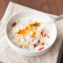 Smoothie bowl with natural yogurt, goji berries, oatmeal flakes and honey