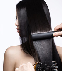 Beautiful brunette girl with a perfectly smooth hair, curling and classic make-up. Beauty face. 