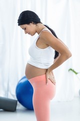 Fototapeta na wymiar Pregnant woman looking down while exercise