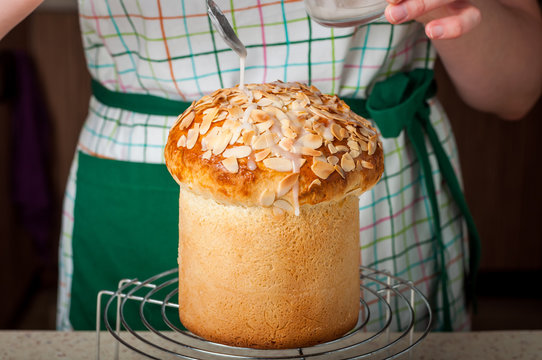 A Woman Dizzling Easter Bread with Sugar Icing