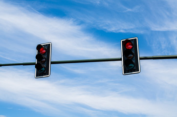 Traffic lights against cloudy blue sky