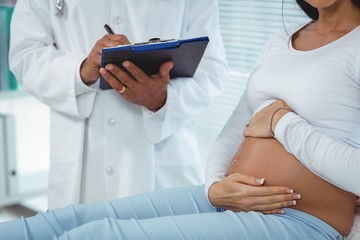 Obraz na płótnie Canvas Pregnant woman interacting with doctor