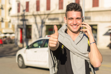 Caucasian man calling taxi service making the sign of ok with his hand