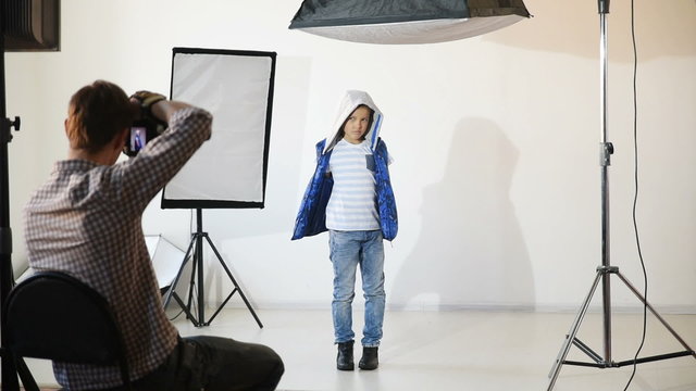 Photographer taking pictures of the child in the studio.