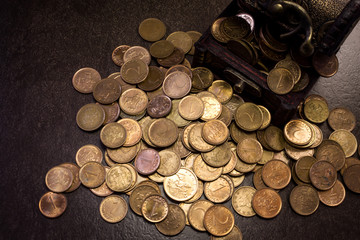 Coins in and out of wooden box 