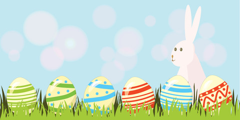 Easter background with copyspace in the sky featuring a cute Easter Bunny and lots of painted Easter Eggs