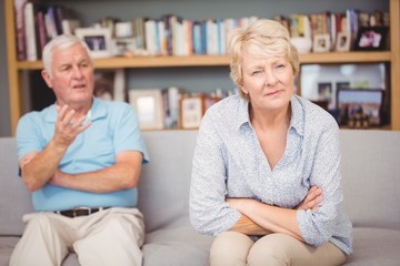 Senior couple arguing while sitting on sofa