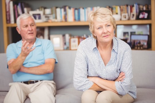 Senior Couple Arguing While Sitting On Sofa