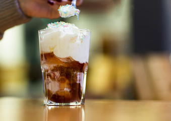 Dessert, chocolate ice cream in a glass. Fresh ice cream in a glass cup covered with whipped cream and sprinkled with icing. 