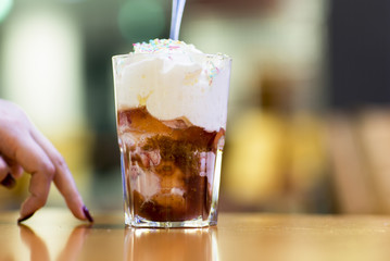Dessert, chocolate ice cream in a glass. Fresh ice cream in a glass cup covered with whipped cream and sprinkled with icing. 
