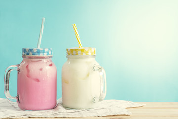 Milkshakes put on wooden in blue wall room. Pastel tone.