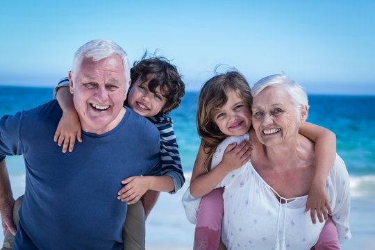 Happy Grandparents Giving Piggy Back To Children