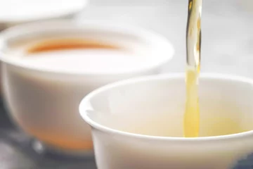 Papier Peint photo autocollant Theé Pouring tea into a bowl horizontal