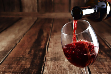 Red wine is pouring from bottle to glass