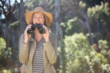 Smiling woman using binoculars