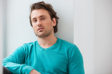 Portrait of handsome relaxed young man in blue jumper