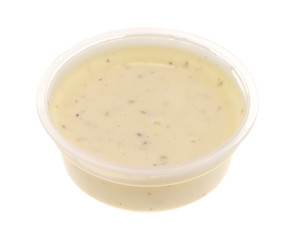 Container of ranch dressing on a white background