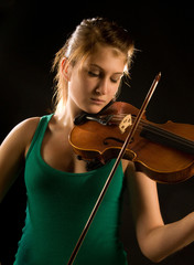 Pretty teenage girl playing violin
