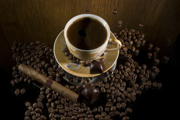 Hot coffee, coffee beans , cigar and chocolate