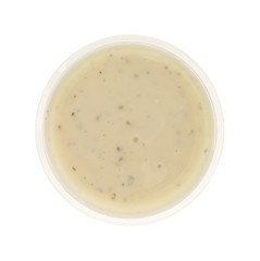 Container of ranch dressing on a white background top view