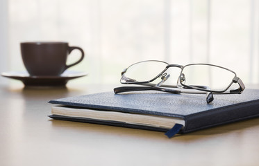 Naklejka premium Glasses and a book on the desk