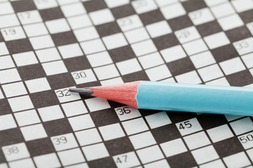 Closeup crossword puzzle and blue pencil