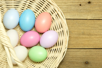 Obraz na płótnie Canvas Easter eggs in the basket on wood background