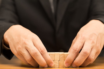 Hand of businessman arrange wood piece