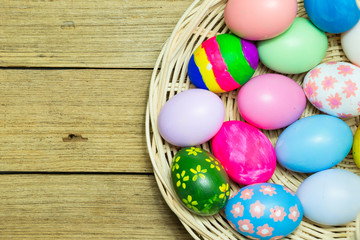 Fototapeta na wymiar Easter eggs in the basket on wood background