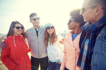 happy teenage friends in shades talking on street