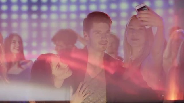 blond girl taking a selfie with her friends on the dancefloor