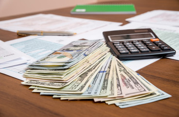 us tax form with dollar and calculator on desk