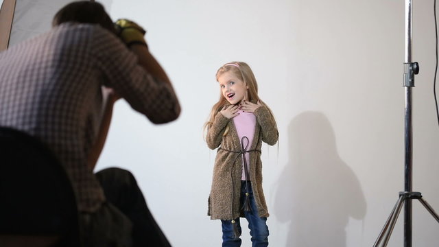 Photographer taking pictures of the child in the studio.