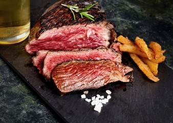 fried steak and beer on a dark background
