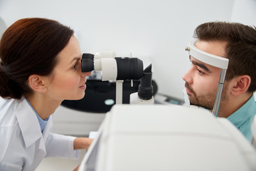 optician with tonometer and patient at eye clinic