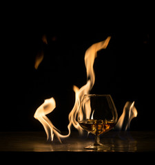 A glass of brandy on the background of fire