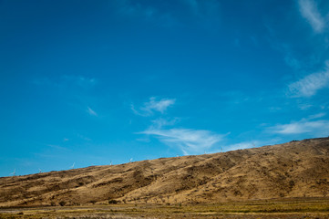 Fototapeta na wymiar Distant wind turbines on a dry hill