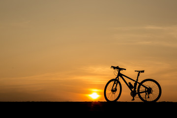 Fototapeta na wymiar silhouette of bicycle on sunset sky