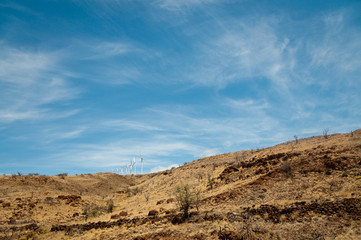Row of wind turbines on a dry hill