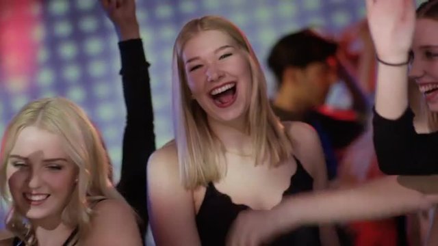 attractive girls on dacefloor at club flirting with dj