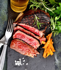 fried steak and beer on a dark background