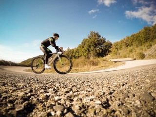 ciclista si allena in salita lungo una strada di montagna