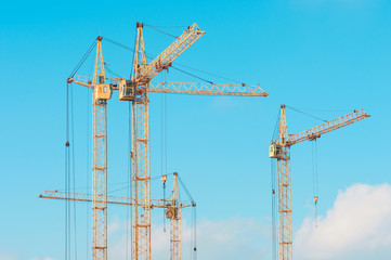 Construction site with cranes against blue sky