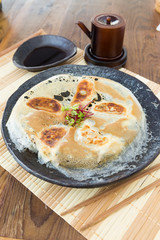 Chicken Gyoza, japanese pan fried dumplings served on a rustic plate.