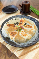 Chicken Gyoza, japanese pan fried dumplings served on a rustic plate.